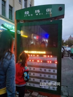 市民正在查看电子站牌上显示的公交车位置 - 新浪黑龙江